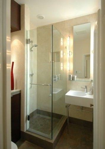 brown wooden vanity with white sink above beside white toilet and glass shower door