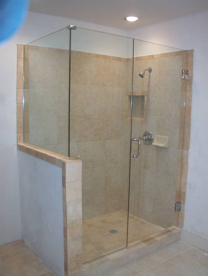 glass shower room with sliding door connected by stainless steel shower on wall tile