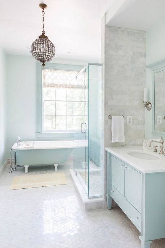 Bathroom featuring blue tiles wall and flooring along with a double sink and corner tub
