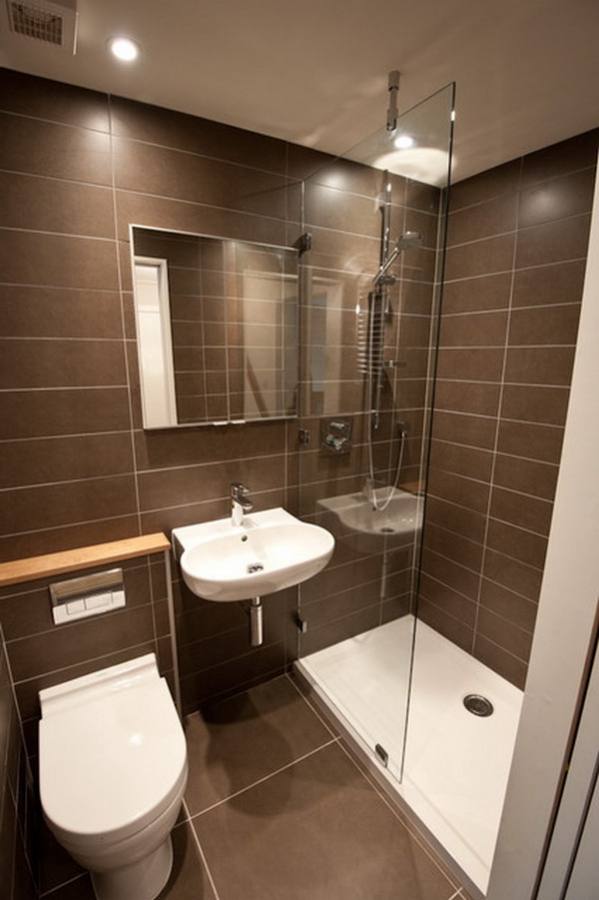 Bathroom featuring blue tiles wall and flooring along with a double sink and corner tub