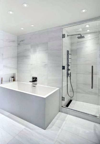 rectangle white bathtub in glass shower stalls with stainless shower on grey tile wall