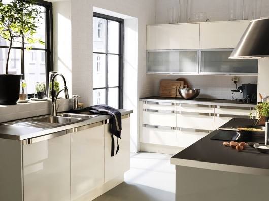 A kitchen cabinet section with open drawers showing glassware, plates and utensils