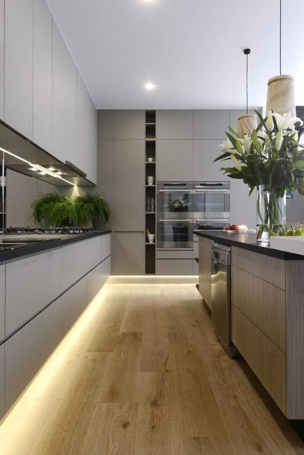 Lighting and flooring create a fusion between the various shades of gray in the kitchen [