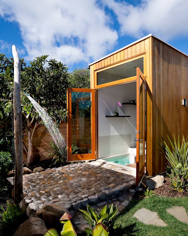 Bathroom with white decor is in the open air next to the pool, by Jen Langston Interiors