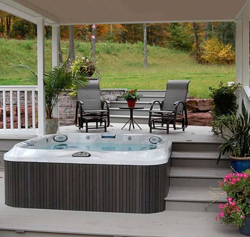 Outdoor living poolside including spa with copy space on pool deck