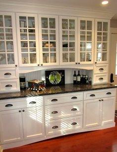 Look for a unique combination of patterns and materials! A textured  backsplash complements these shiny kitchen cupboards wonderfully