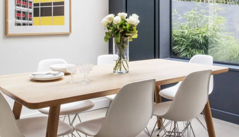 table against the wall, two chairs, one bench seat