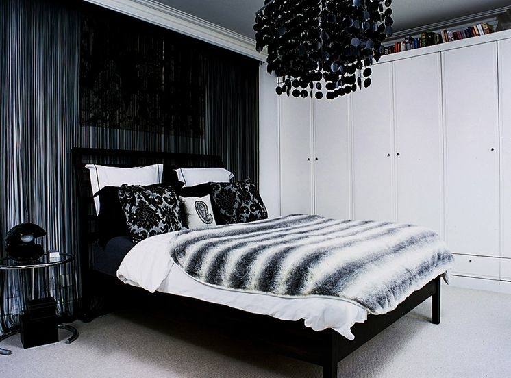 Go monochrome in your bedroom by decorating a black bed with white decorative pillows