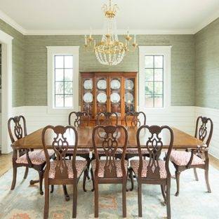 Wooden dining  table and chairs combine with chandelier and red rose on the table makes  this