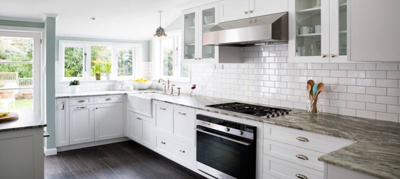 Bright orange painted cabinets and drawers certainly brighten up a white kitchen